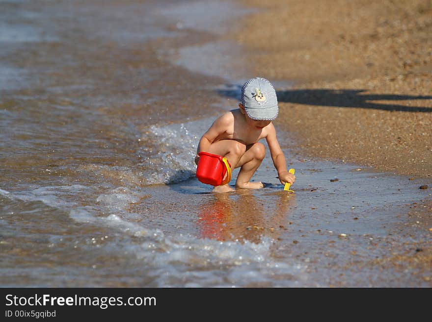 Small Kid play with buckets and shovel on the beach. Small Kid play with buckets and shovel on the beach