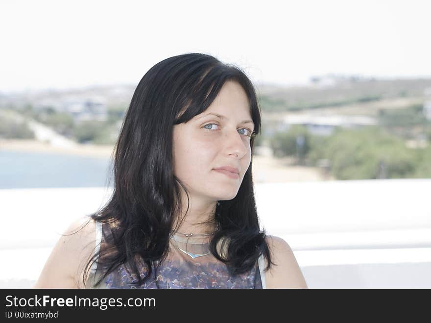 Attractive young woman with slight smile sitting in greek island cafe. Attractive young woman with slight smile sitting in greek island cafe