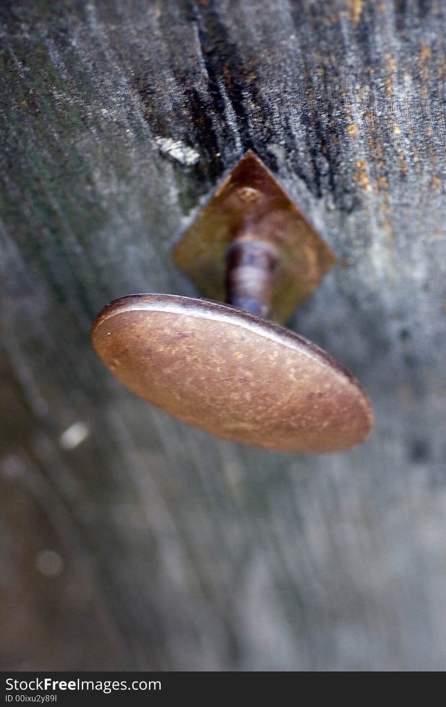 Old-fashioned doorknob in weatherworn wooden door. Old-fashioned doorknob in weatherworn wooden door