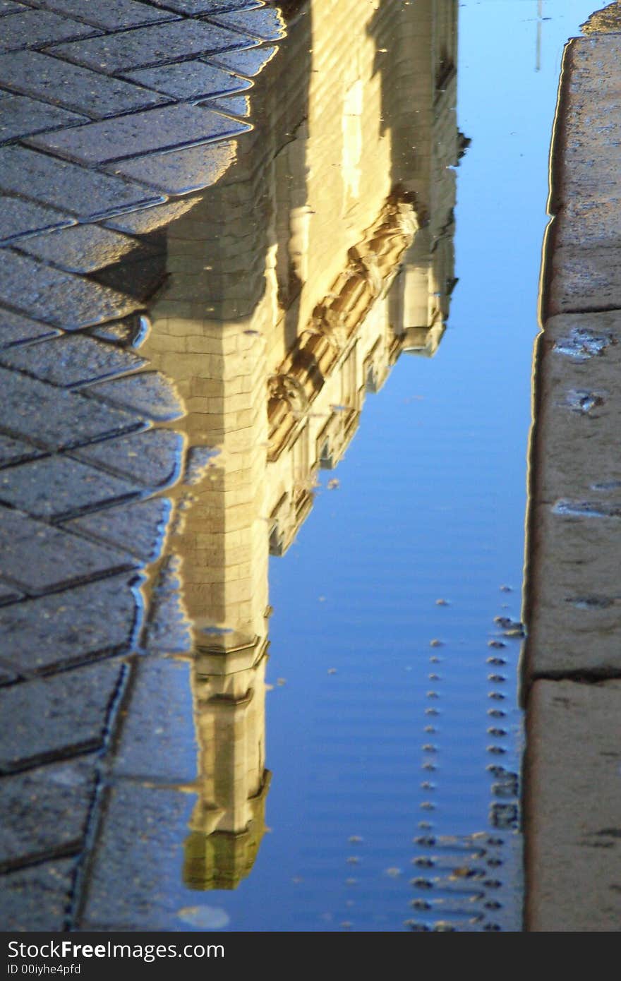 Gonville & Caius College, Cambridge University, England - Reflected in a puddle over a drain. Gonville & Caius College, Cambridge University, England - Reflected in a puddle over a drain