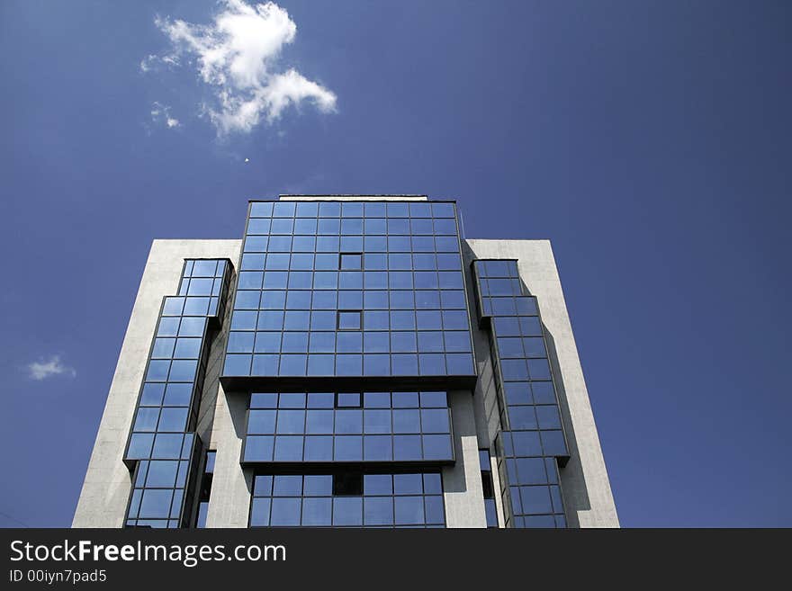 Office building and a small cloud on a blue sky