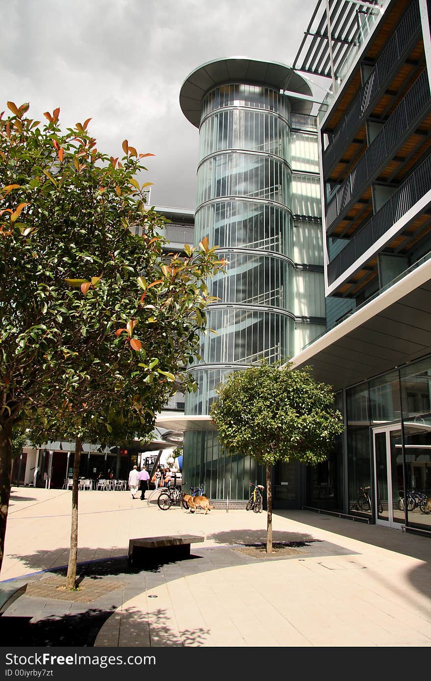 Shop and Apartment block with threatening stormy clouds above and people walking about. Shop and Apartment block with threatening stormy clouds above and people walking about