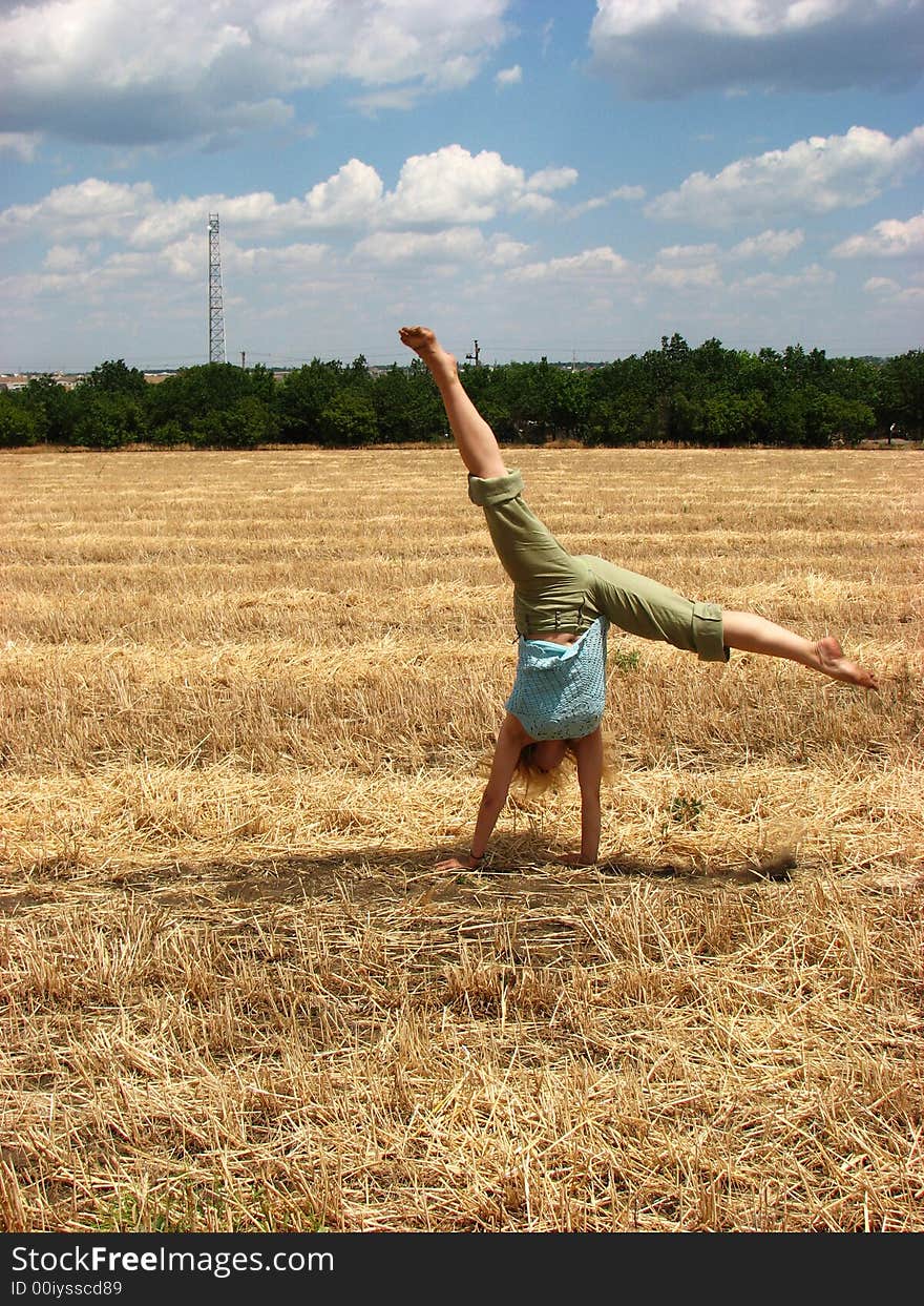 Young woman in yellow field do handsprings. Young woman in yellow field do handsprings