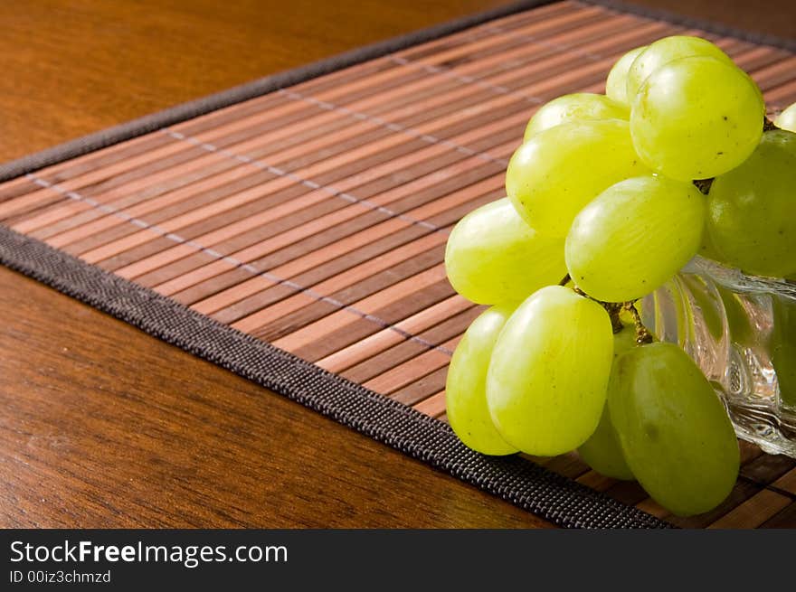 Juicy green grape on a glass vase. Juicy green grape on a glass vase