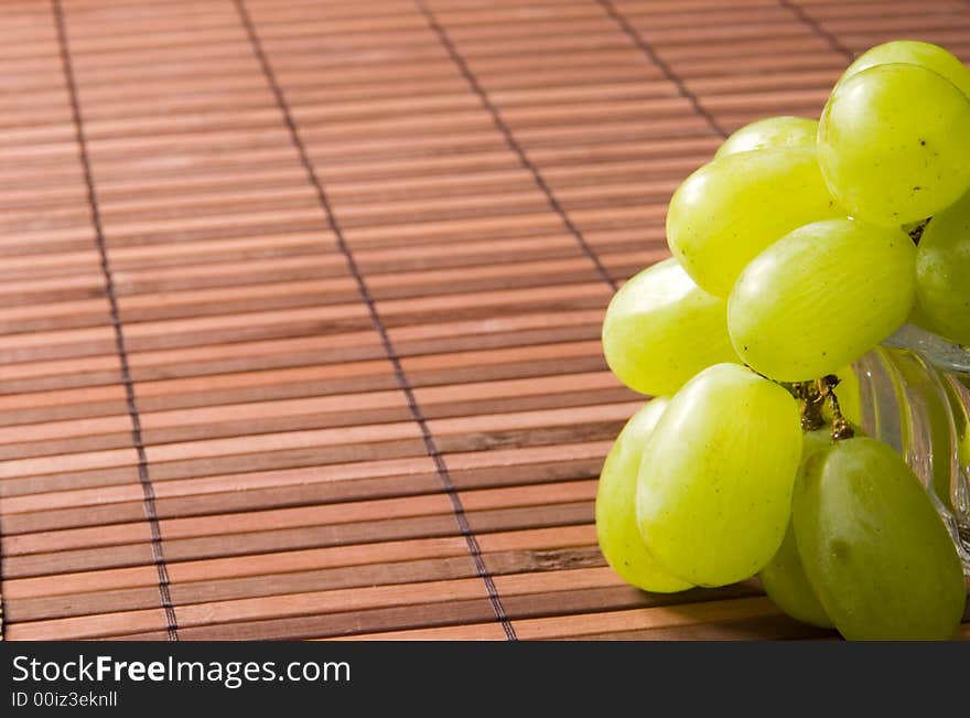 Juicy green grape on a bamboo napkin. Juicy green grape on a bamboo napkin