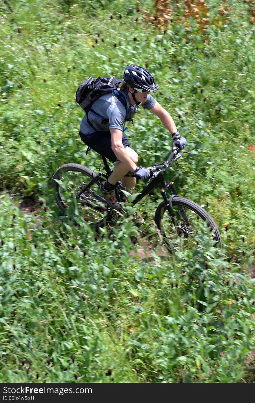 A cross country mountain biker on a trail photograhed using motion panning. A cross country mountain biker on a trail photograhed using motion panning