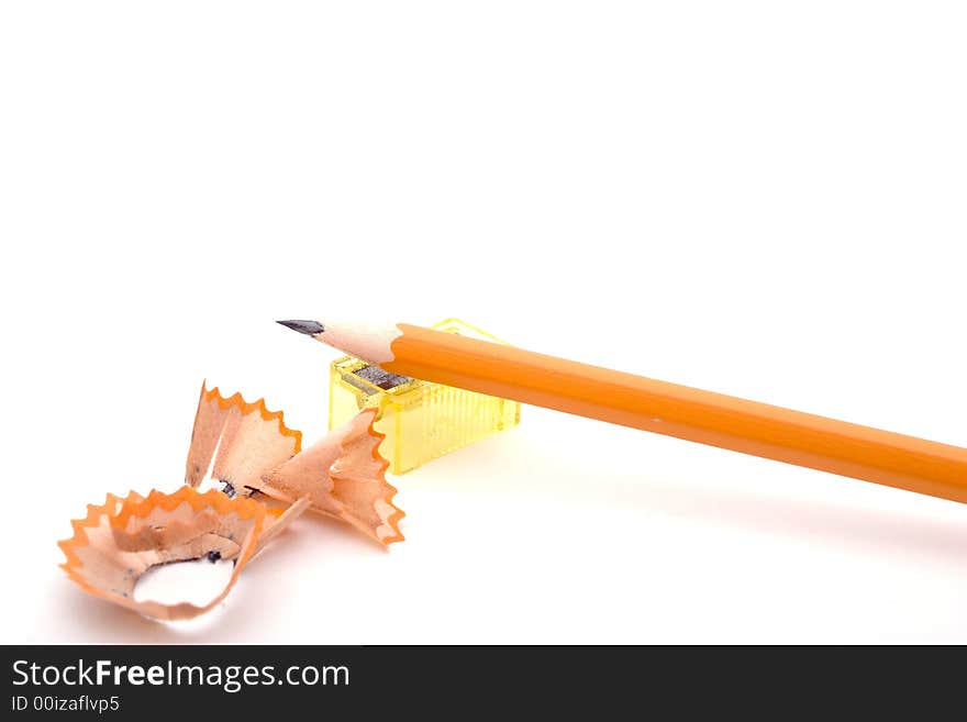 A sharpened pencil, the pencil sharpener and the shavings, isolated on white