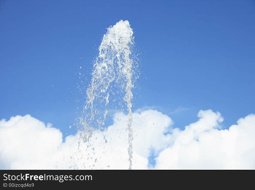 Fountain on a background of clouds and the dark blue sky