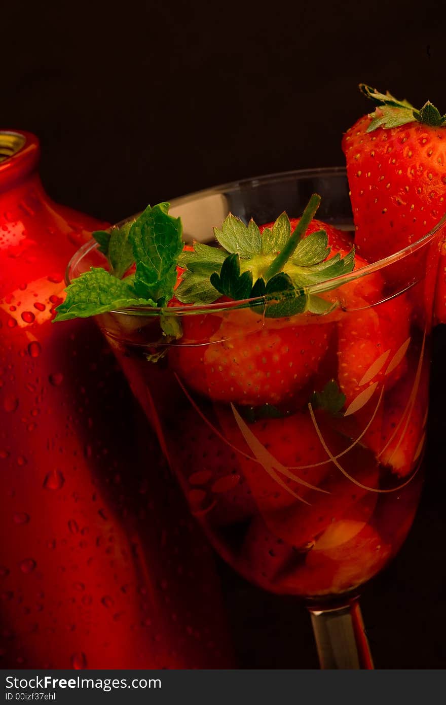 Strawberry ice cocktail with cocktail shaker on black background. Strawberry ice cocktail with cocktail shaker on black background