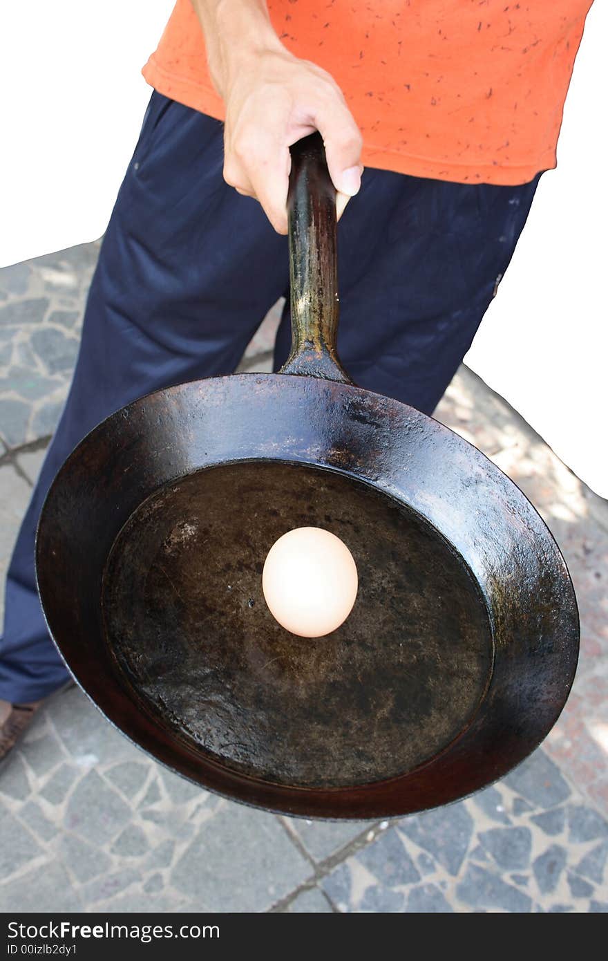 The person holds a frying pan with an egg