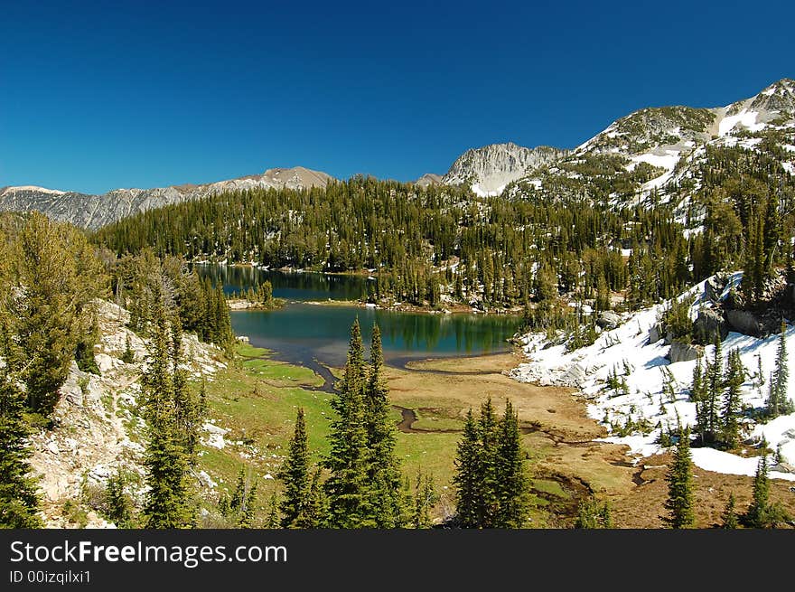 An alpine lake nestled amongst snowcapped mountains. An alpine lake nestled amongst snowcapped mountains