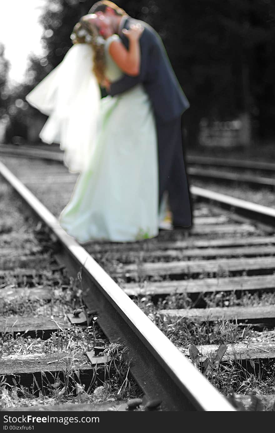 The groom and bride kiss on railway. The groom and bride kiss on railway