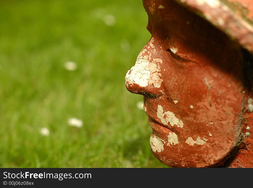 Photo of red stoned face on the grass