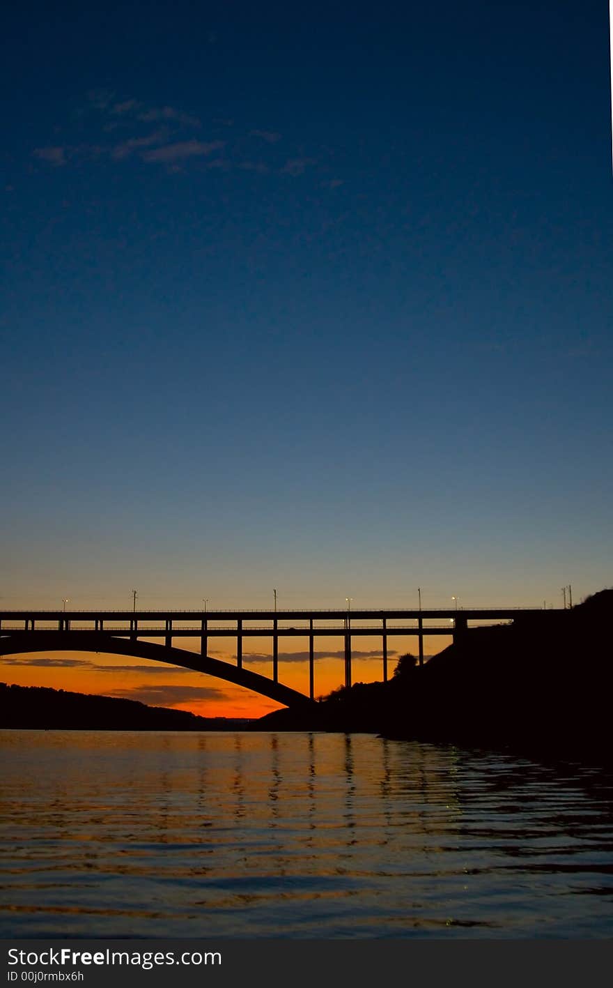 Bridge at night time reflecting in the water. Bridge at night time reflecting in the water