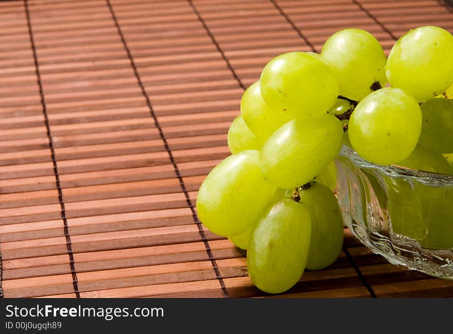 Juicy green grape on a glass vase. Juicy green grape on a glass vase