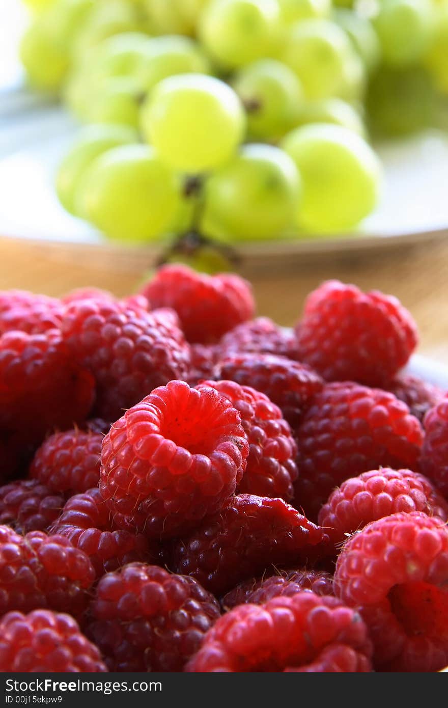 Raspberries and grapes in background