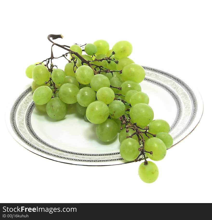 Grape cluster on a plate isolated on white background. Grape cluster on a plate isolated on white background