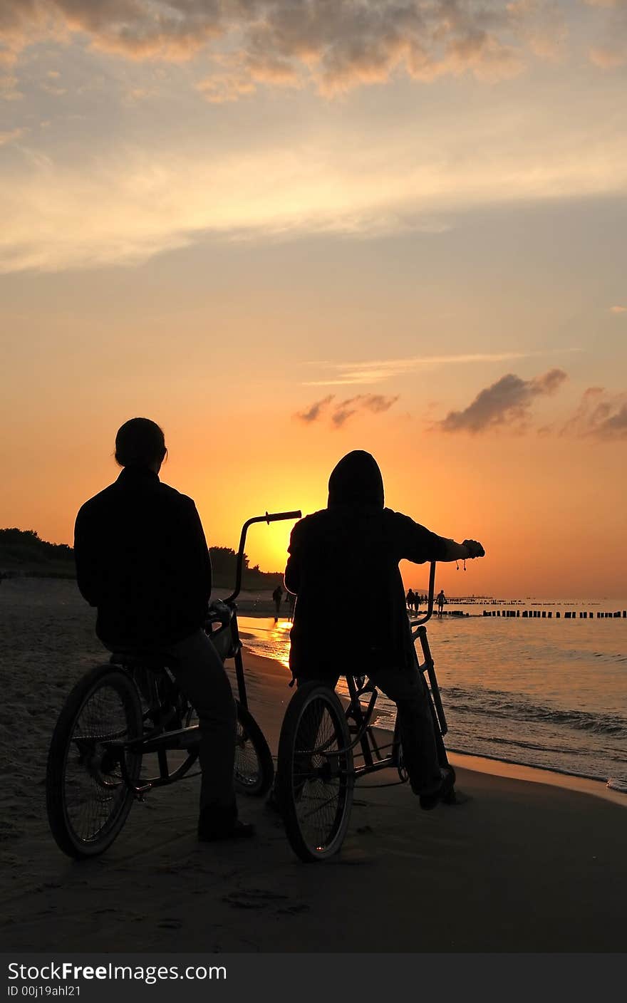 Bikers admiring sunrise during cloudy day