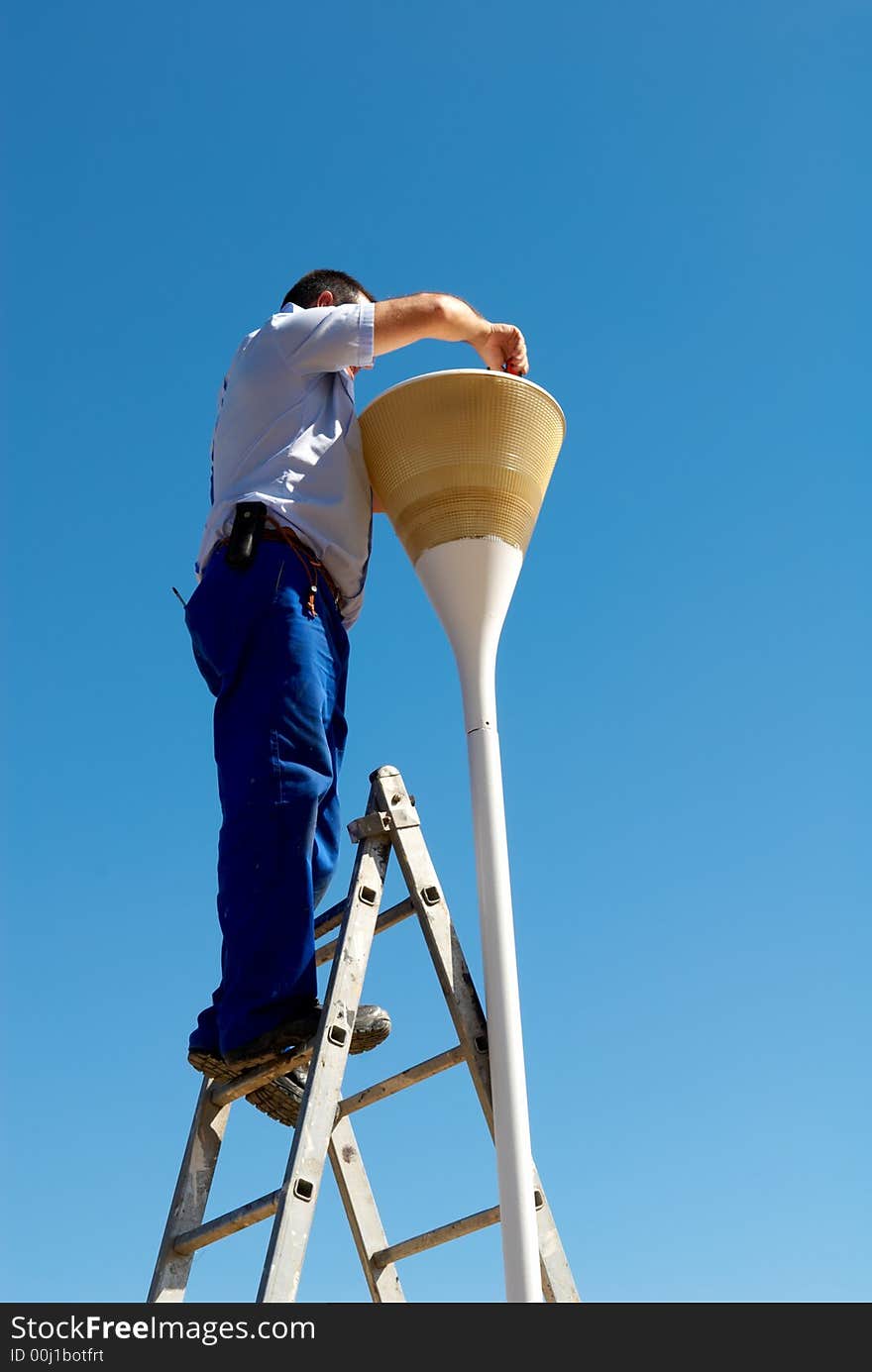 Man changing the lamp against blue