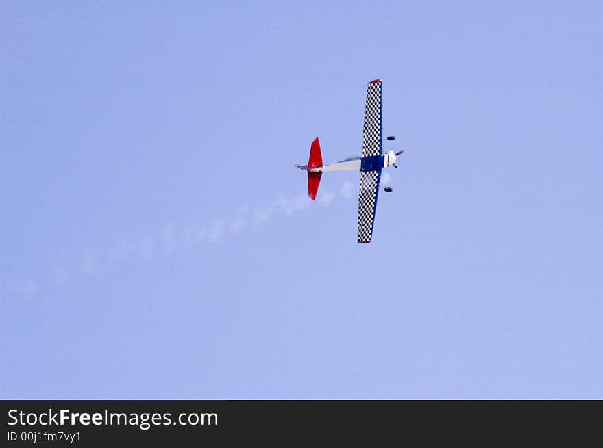 Airplane flying in blue sky with smoke