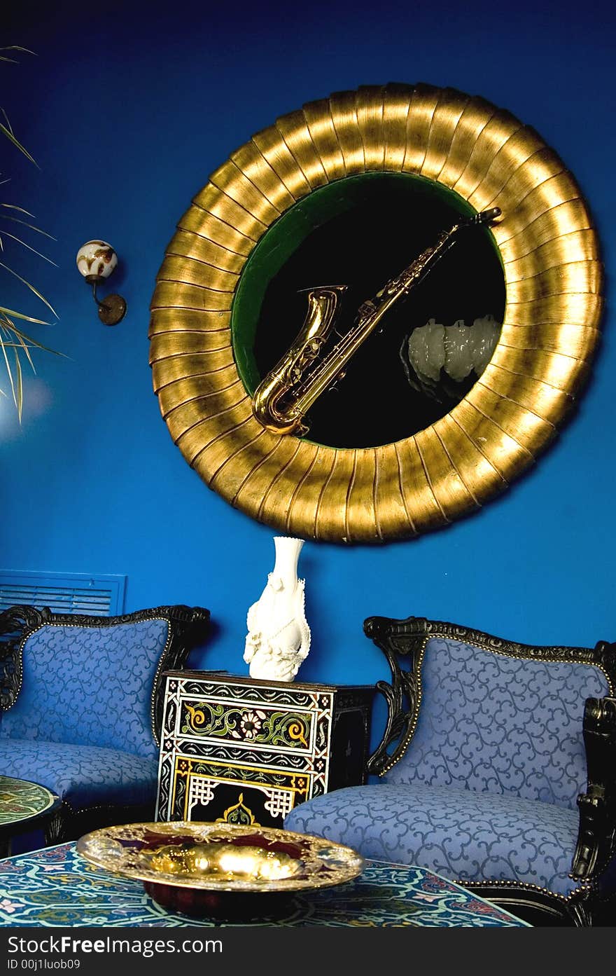 Blue room whit old saxophone picture and blue sofa in a antique  store. Blue room whit old saxophone picture and blue sofa in a antique  store