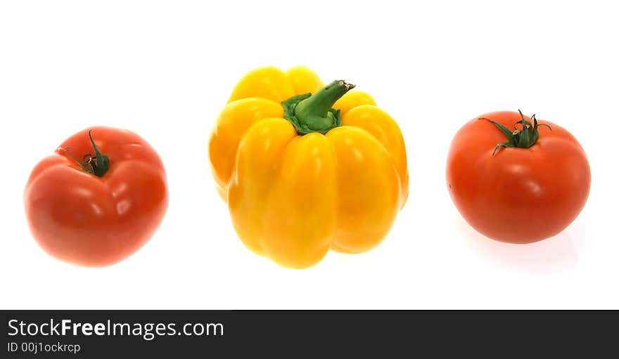 Colorful red tomatos and yellow paprika isolated on white background. This high resolution image was taken by 10 mp Canon camera with professional lens.