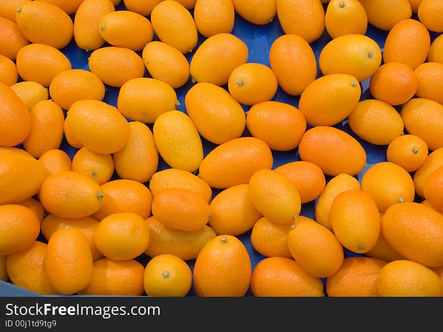 Orange Kumquats in a box with blue background