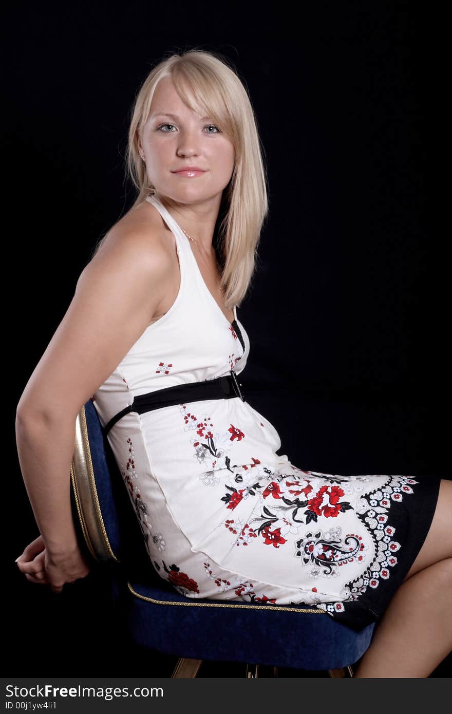 Beautiful young girl sitting on a chair. Beautiful young girl sitting on a chair