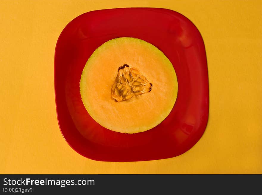 Slice of fresh melon on red plate