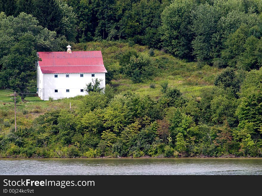 An old shed surrouned by trees on a hill.