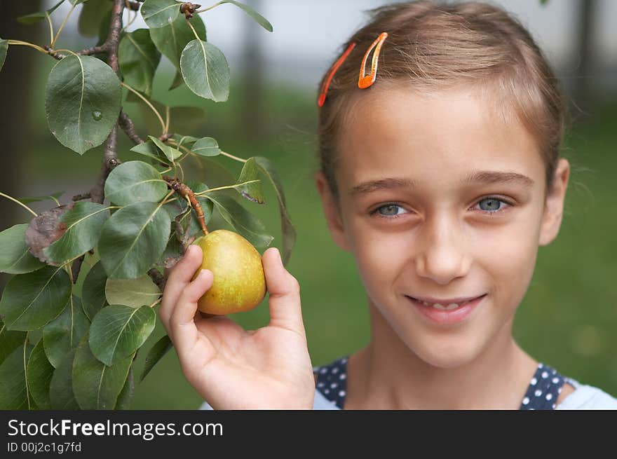 Smiling girl holding a pear in her hand