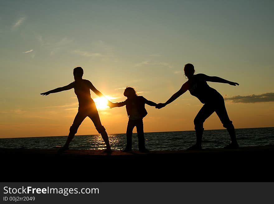 Silhoette of three children holding hands at sunset. Silhoette of three children holding hands at sunset