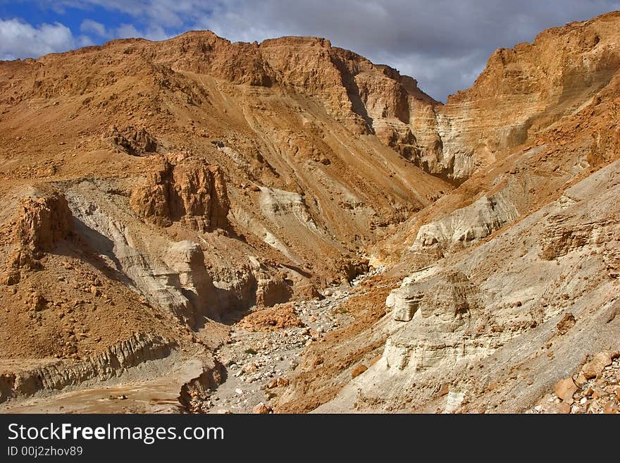 A dry channel of a stream in ancient mountains of the Dead Sea in Israel. A dry channel of a stream in ancient mountains of the Dead Sea in Israel