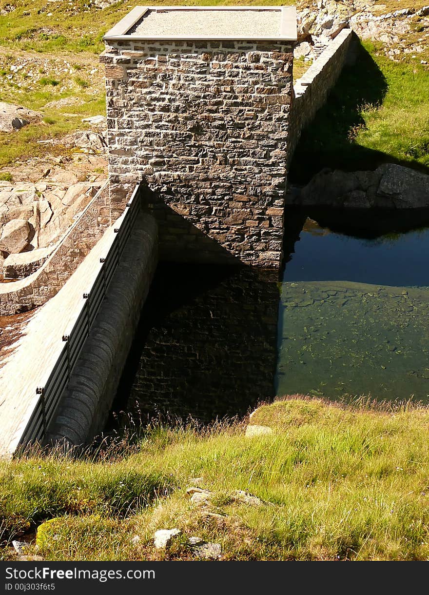 Little dam with a tower. The water reflection is beautiful! There are three kind of reflection (the sky, the tower and a ridge of a mountain) and there is also trasparency (we can see the lakebed). . Little dam with a tower. The water reflection is beautiful! There are three kind of reflection (the sky, the tower and a ridge of a mountain) and there is also trasparency (we can see the lakebed).