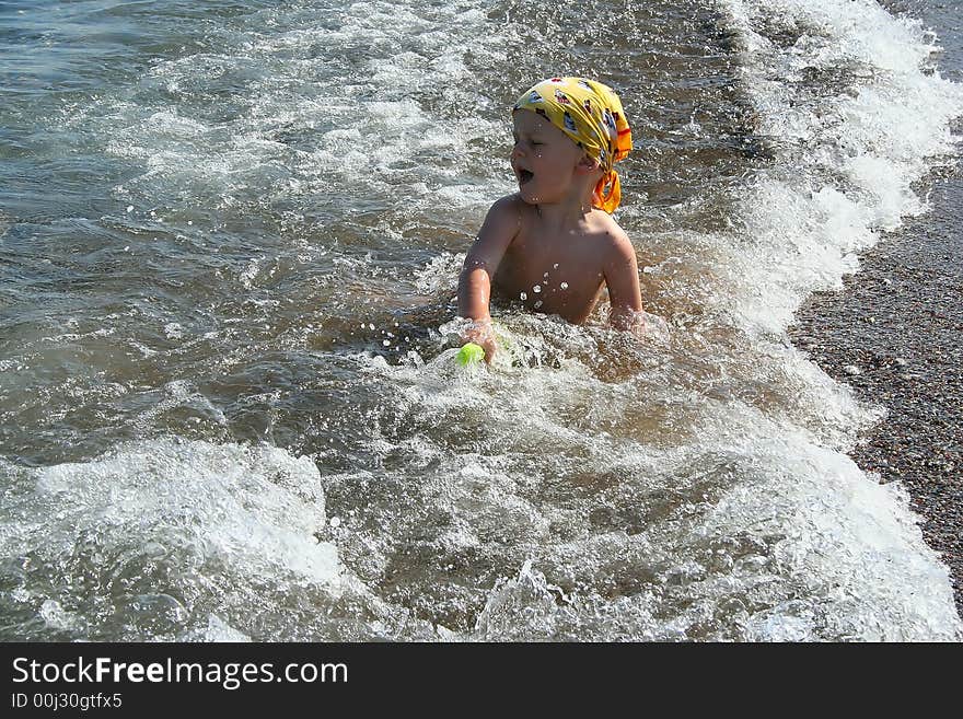 Small boy sitting in shallow sea, Rhodes Island, Greece. Small boy sitting in shallow sea, Rhodes Island, Greece