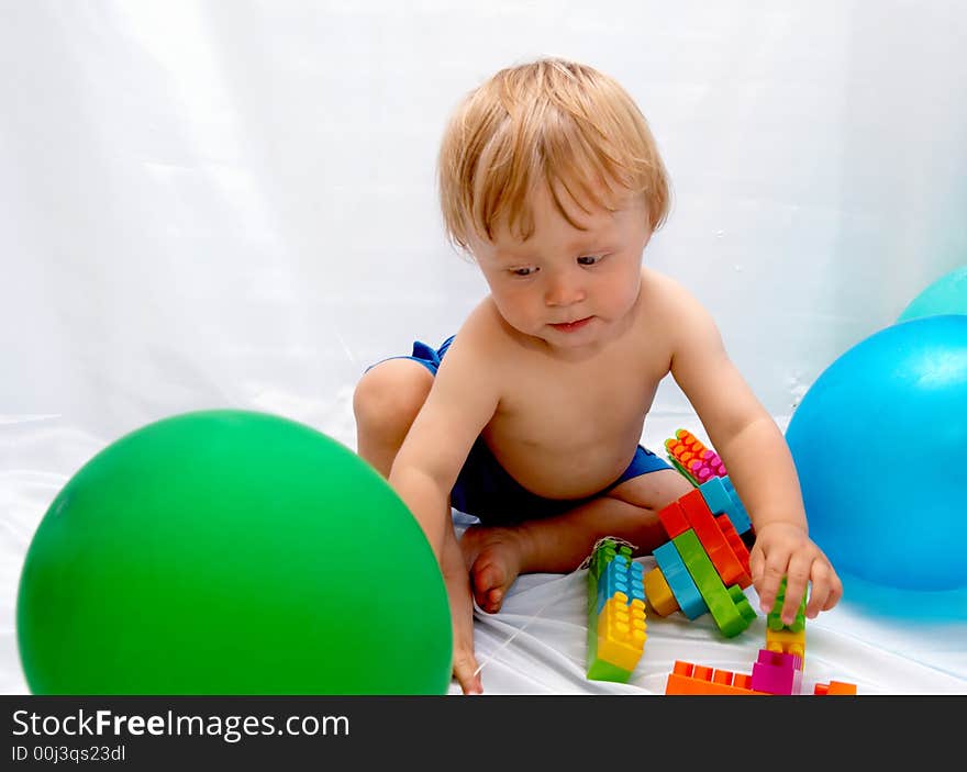 The small boy plays toys on a white background