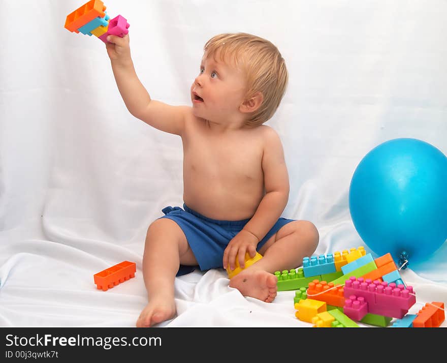 The small boy plays toys on a white background