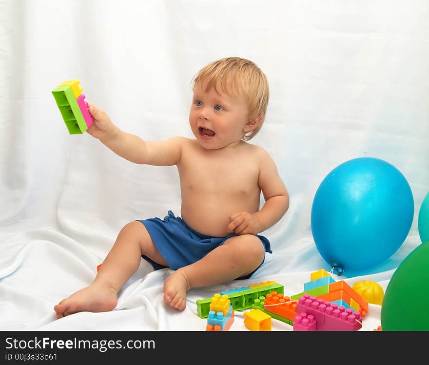 The small boy plays toys on a white background