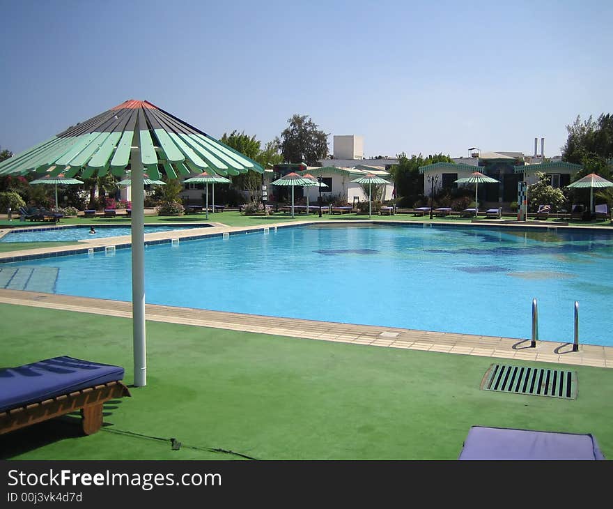 Pool in hotel. It is a lot of umbrellas. Rest.