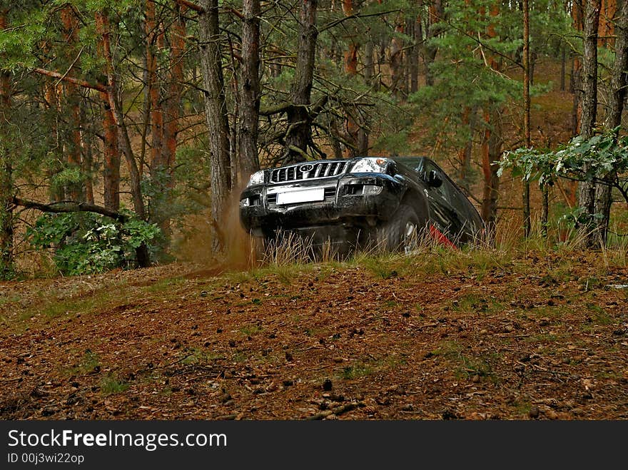 4x4 car in action in the forest. The car is going up on the hill.