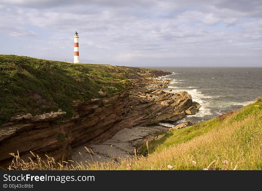 Red and white lighthouse on the cliffs overlooking the North Sea on the east coast of Scotland