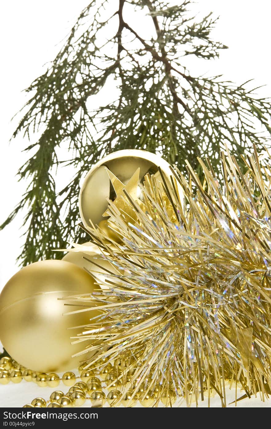 An arrangement of tinsel, golden baubles  and beads on a white background. An arrangement of tinsel, golden baubles  and beads on a white background