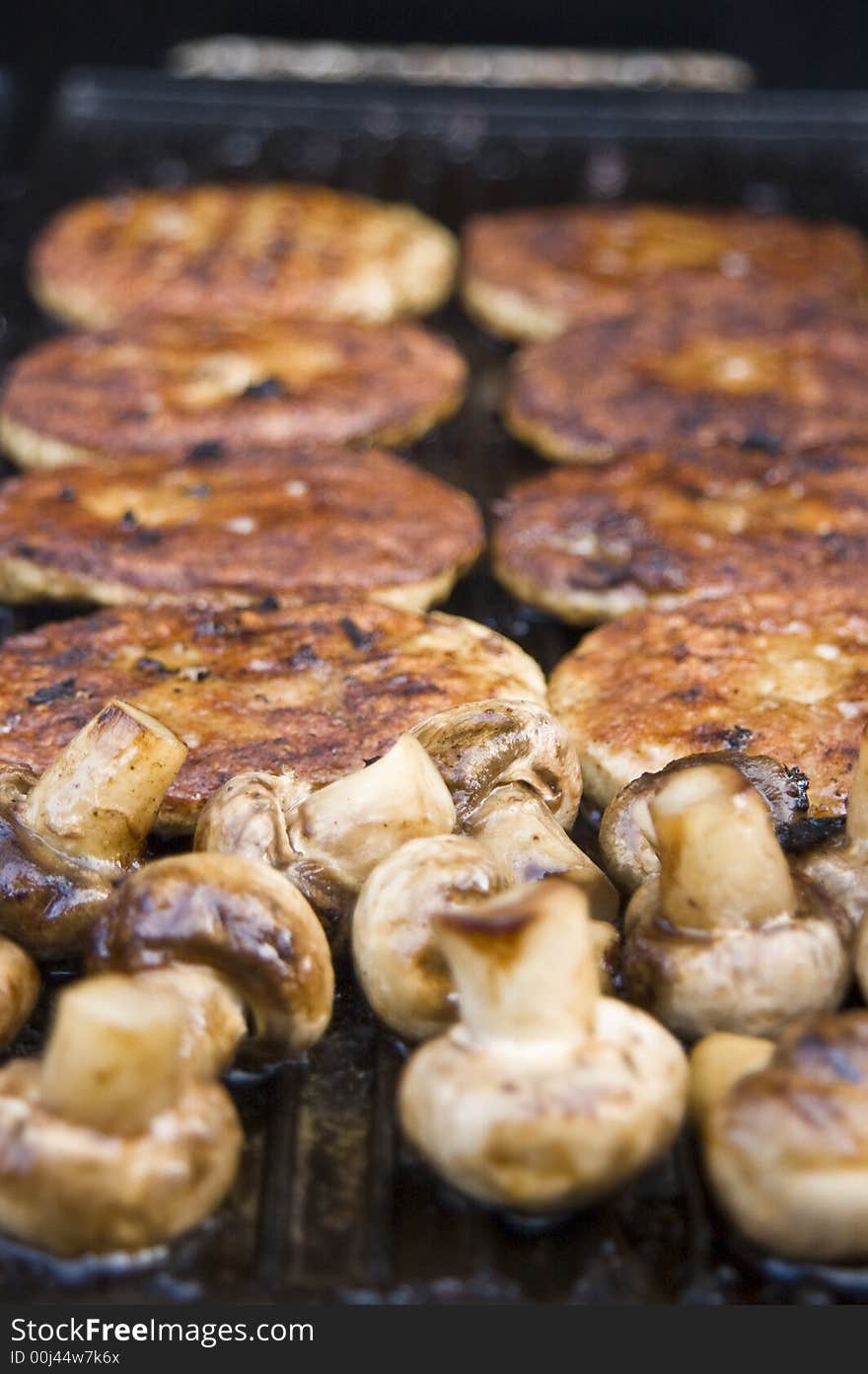 A treat of hot mushrooms and burgers straight from the griddle on the gas barbecue. A treat of hot mushrooms and burgers straight from the griddle on the gas barbecue