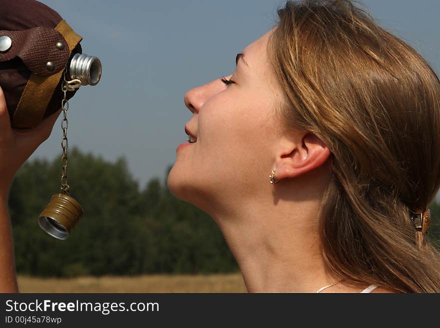 The girl quench thirst with flask in the outdoor