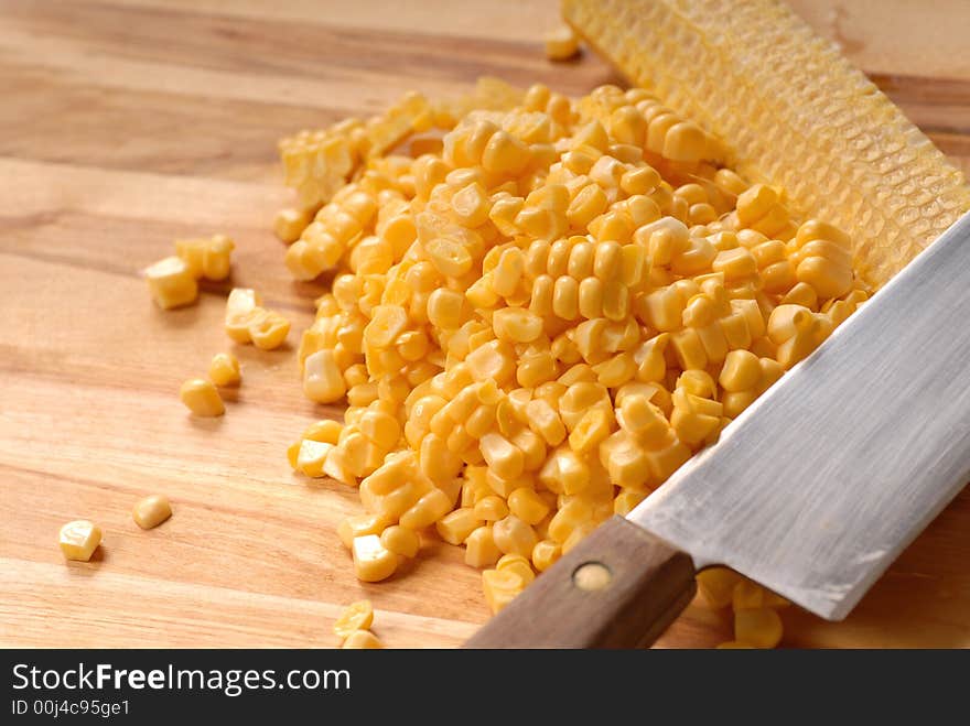 Freshly cut kernels of corn from a corn cob on a cutting board