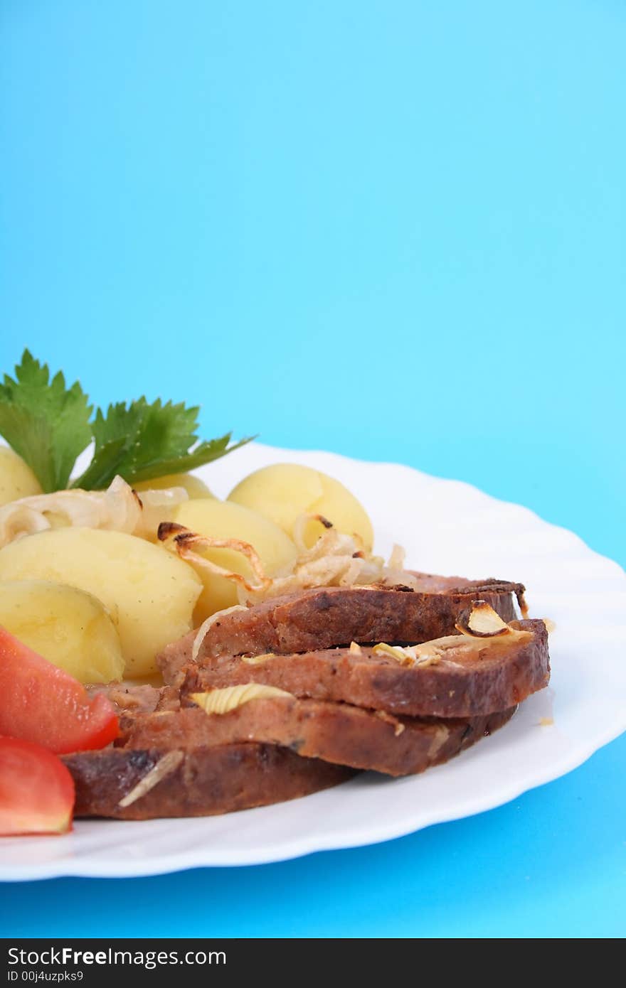 Meat and potatoes on the blue background