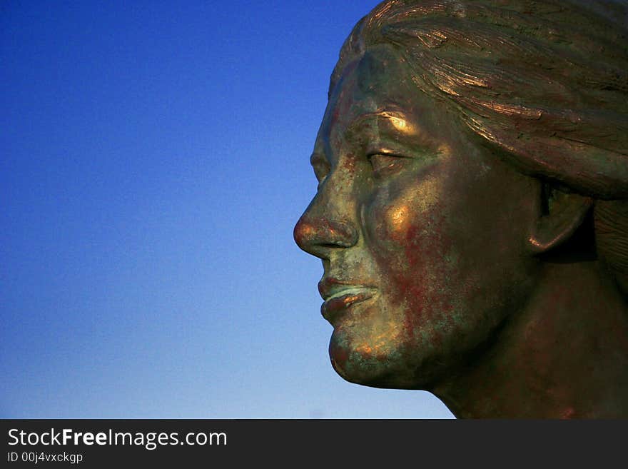 A digital image of an iron ladys face with a blue sky background.