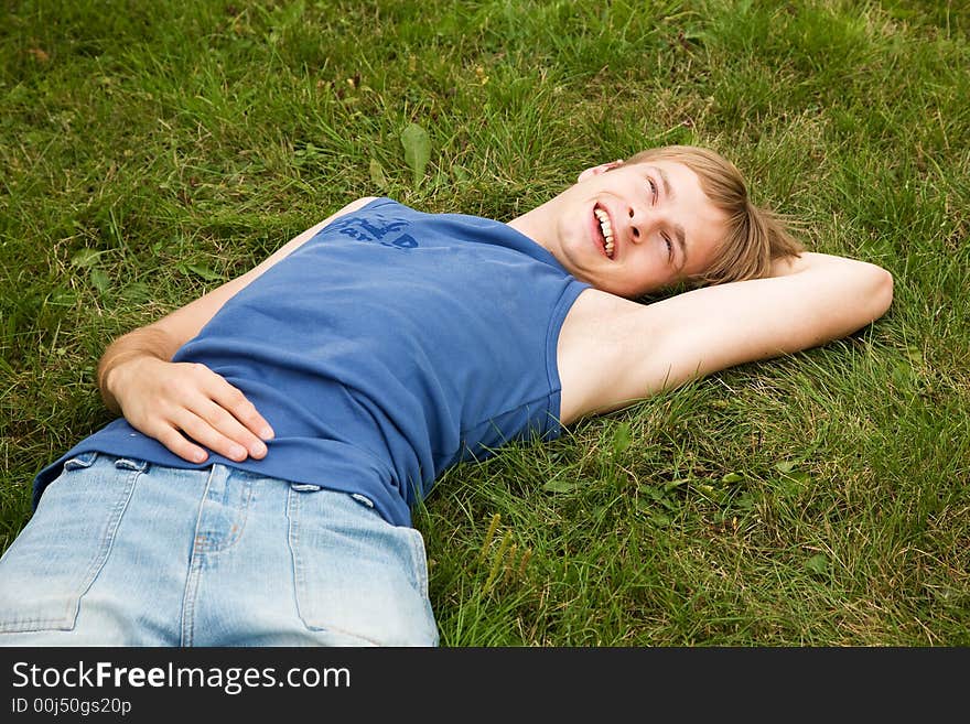 Smiling boy lying on the green grass