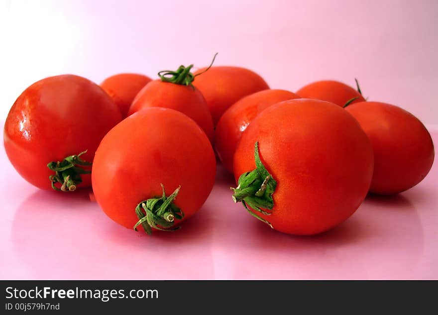 Many tomatoes over pink