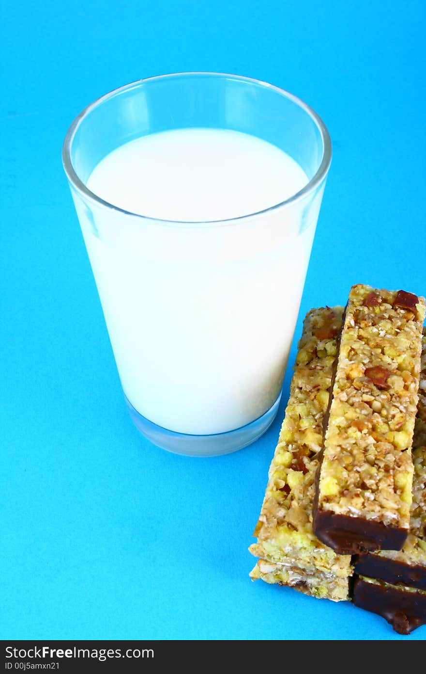 Pouring white milk against blue background and glass. Pouring white milk against blue background and glass